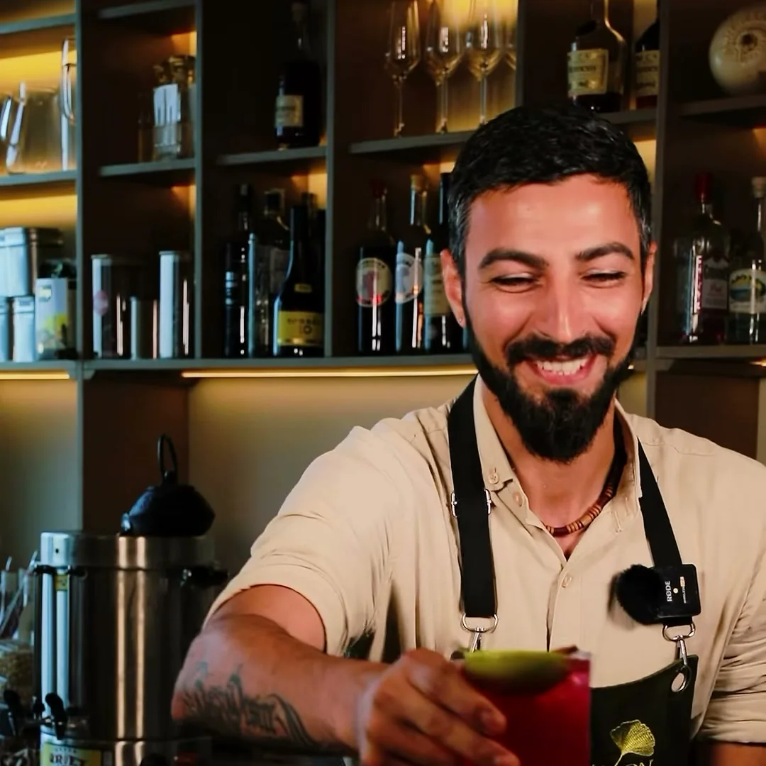 Şüşə rəfləri olan piştaxtanın yanında barmen