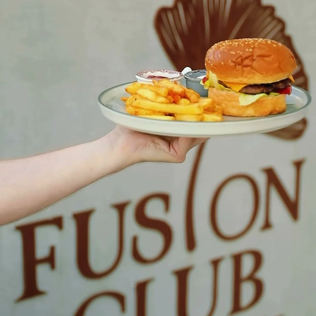 Fusion Club lövhəsi fonunda kartof fri ilə burger