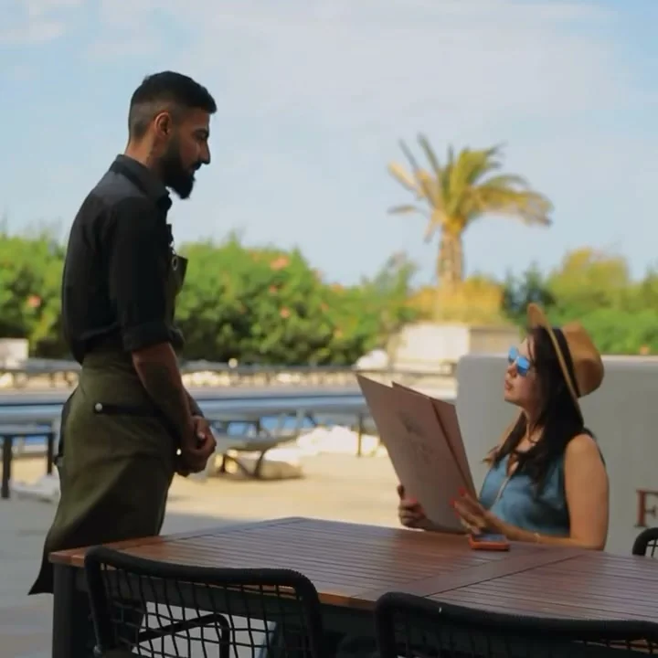 Hovuz kənarında terras: ofisiant və menyulu qonaq xanım